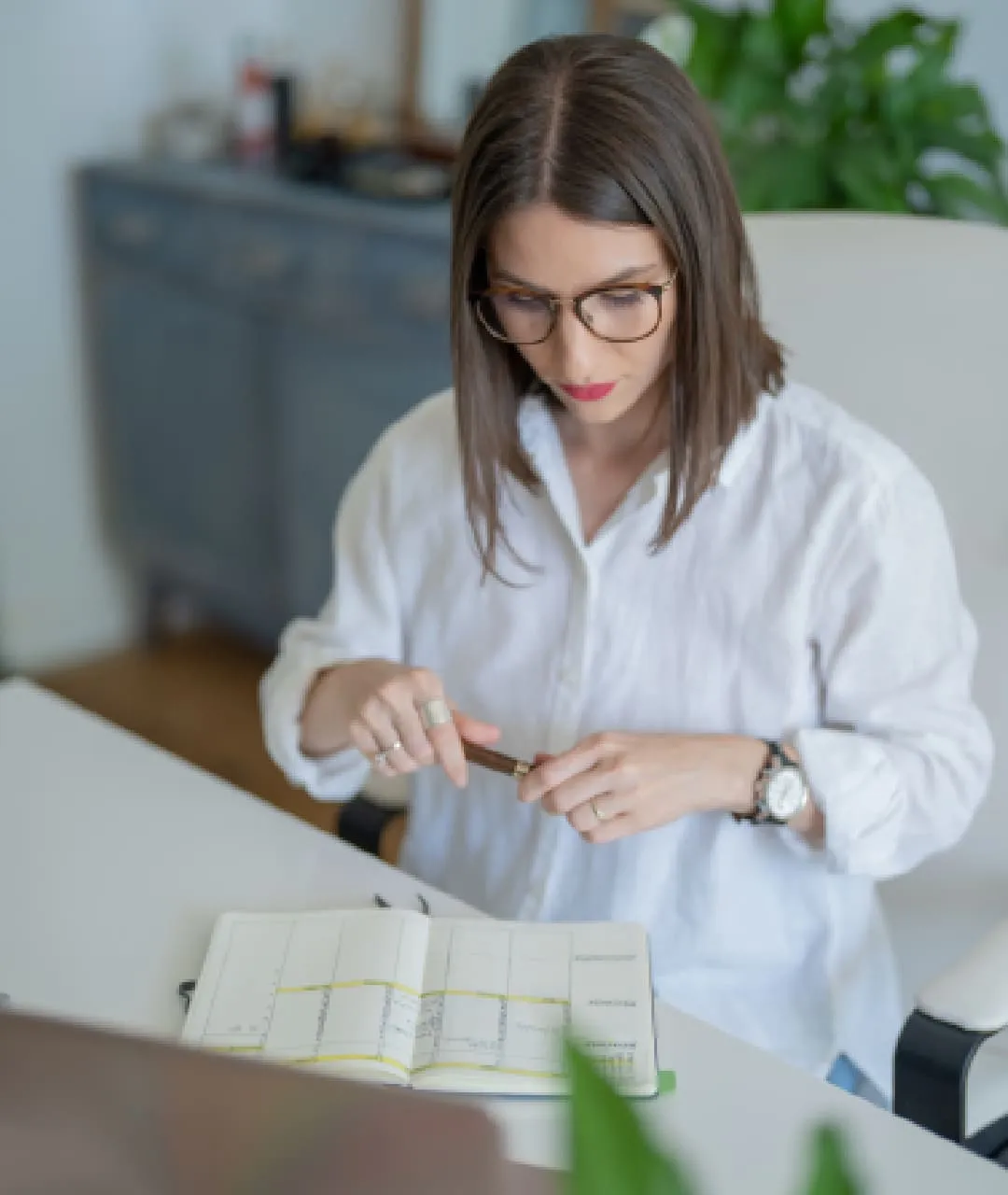 Person som planlegger og noterer ved et skrivebord